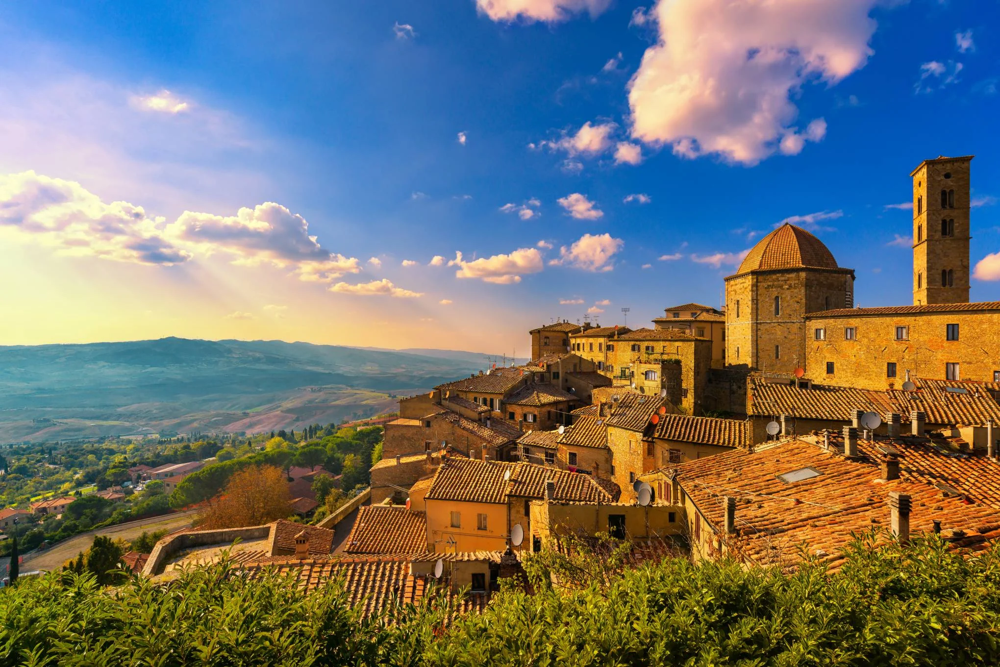La luz del atardecer sobre los tejados y las colinas de la Toscana
